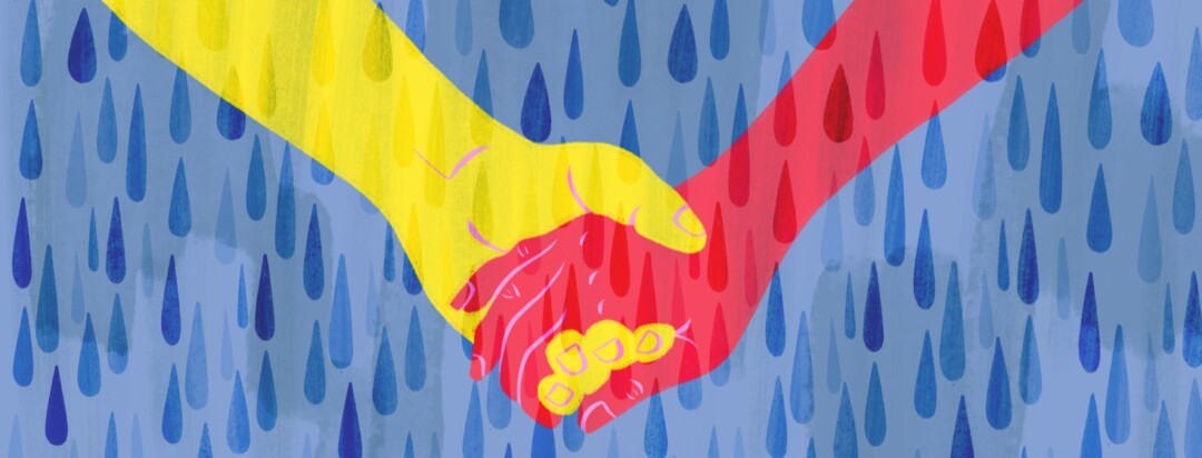 Two hands holding in the middle of a rain shower